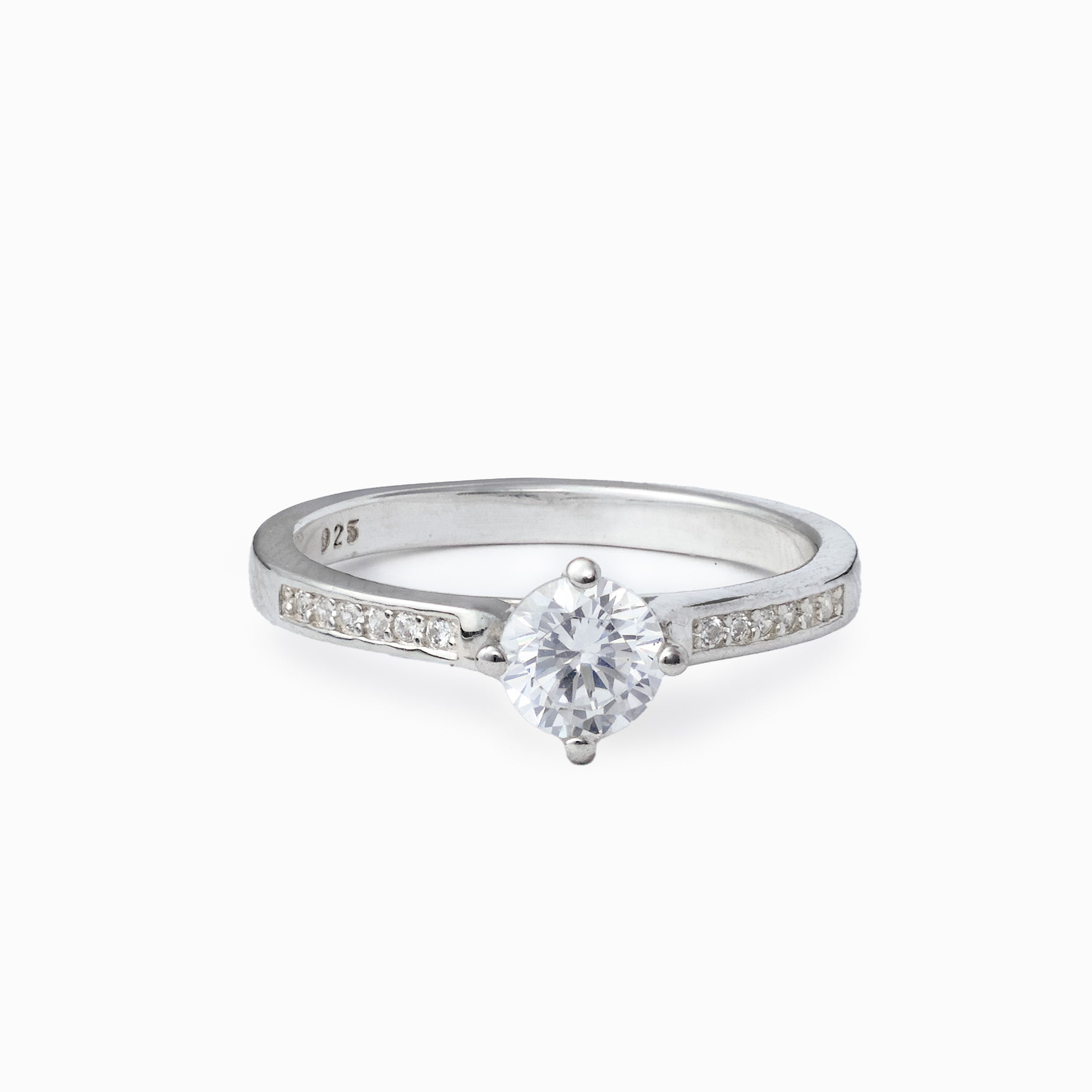 Anillo solitario fino en Plata Ley 925 talla 8 con piedra central transparente y banda con apliques brillantes sobre fondo neutro.
