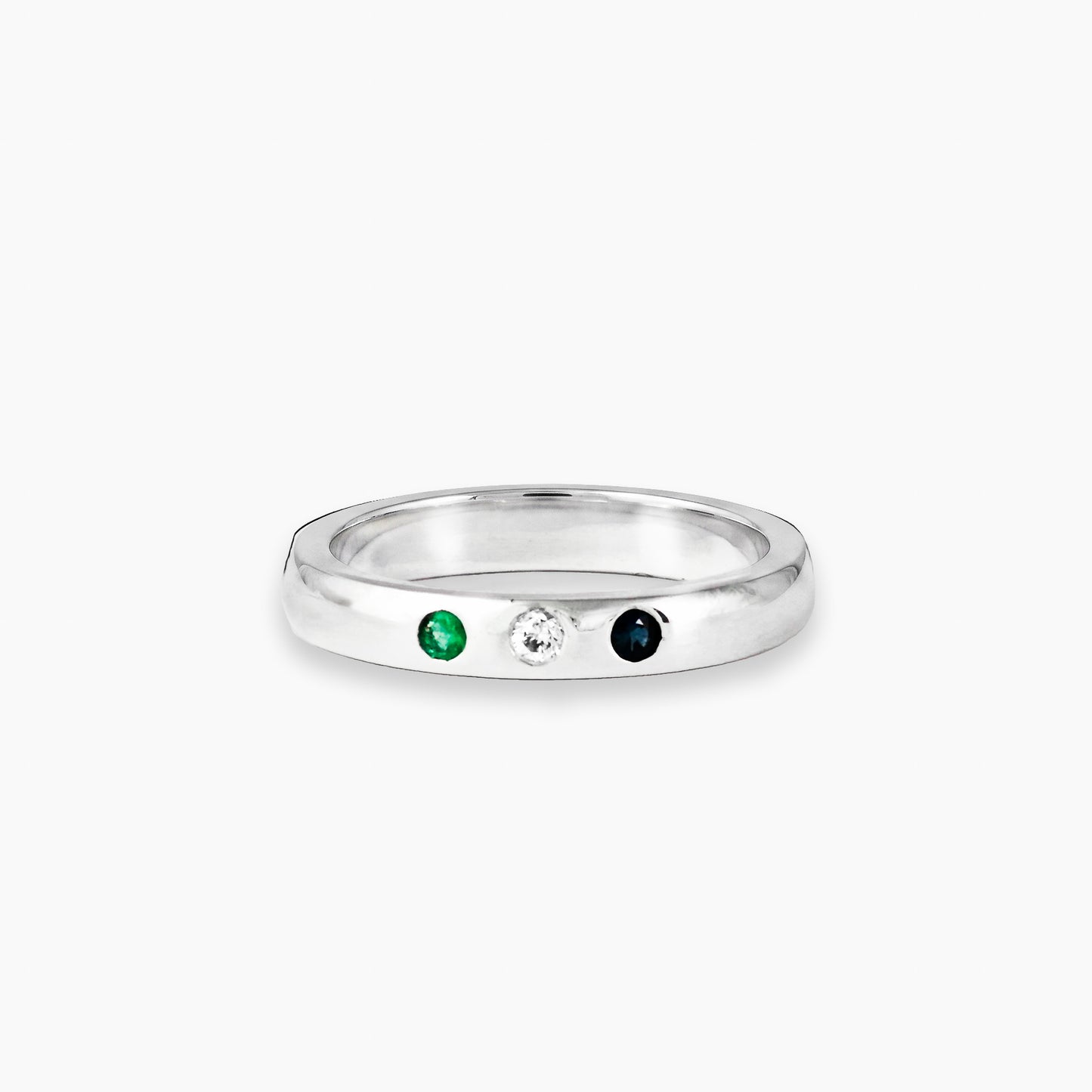 Argolla lisa de Plata Ley 925 pulida talla 6.5 con una esmeralda, un diamante y un zafiro engastados en línea.