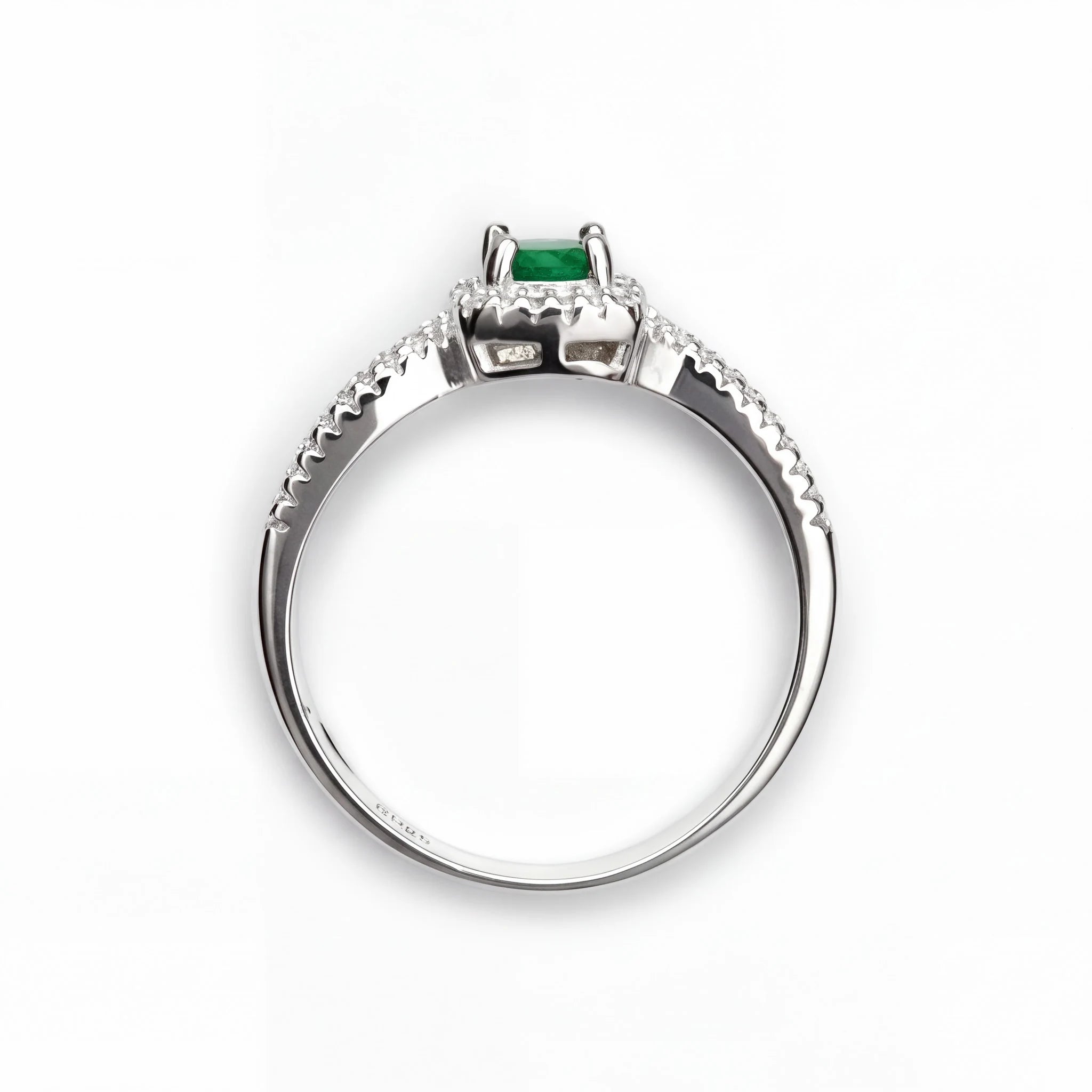 Anillo de halo en plata ley 925 con esmeralda natural central y circones en la banda.