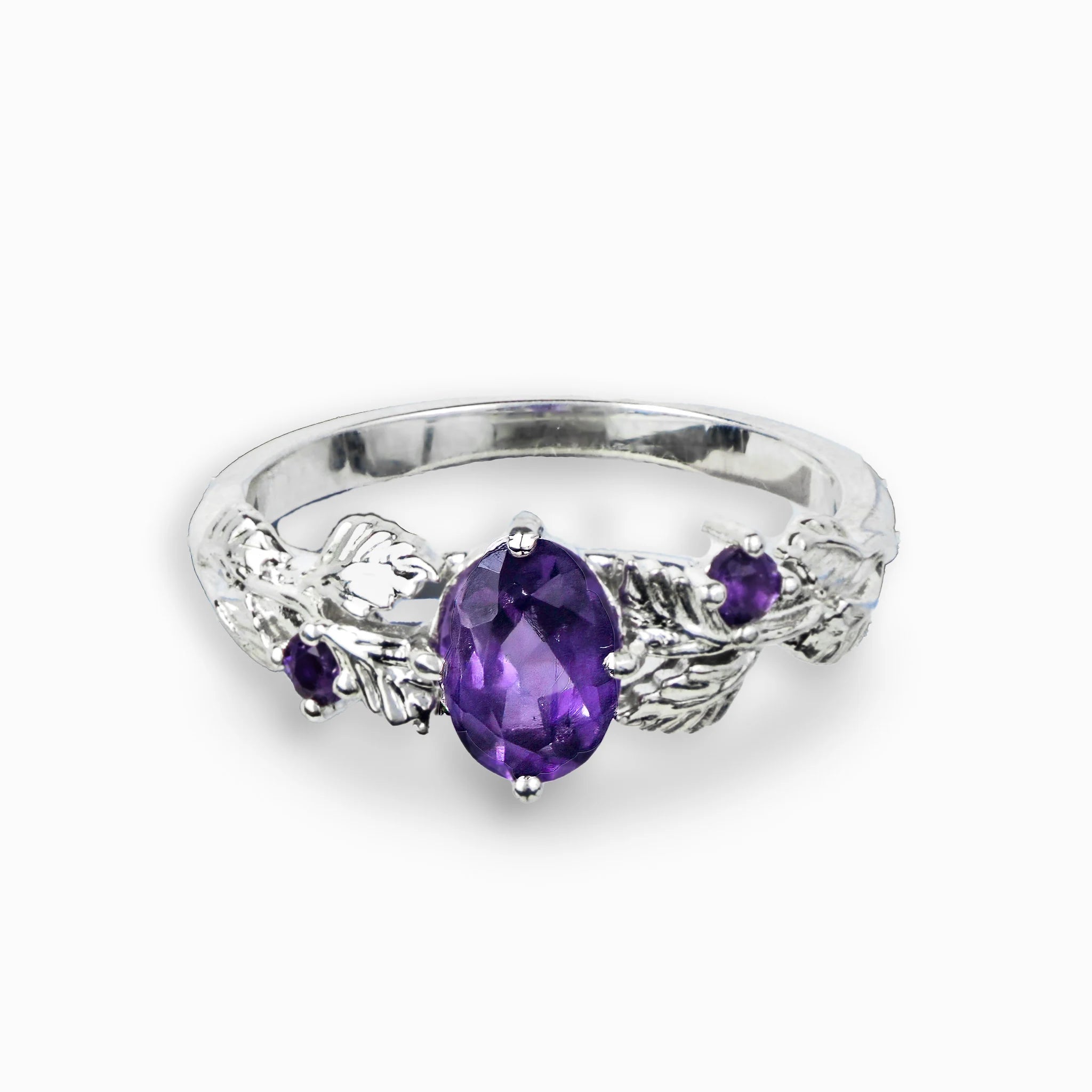 Anillo de plata ley 925 con diseño de hojas y amatista central.