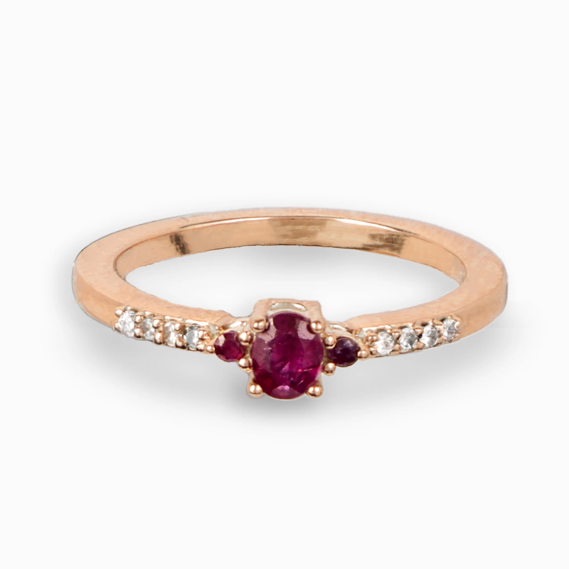 Anillo en oro rosa con rubí central y diamantes laterales.