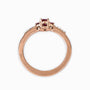 Anillo en oro rosa con rubí central y diamantes laterales.