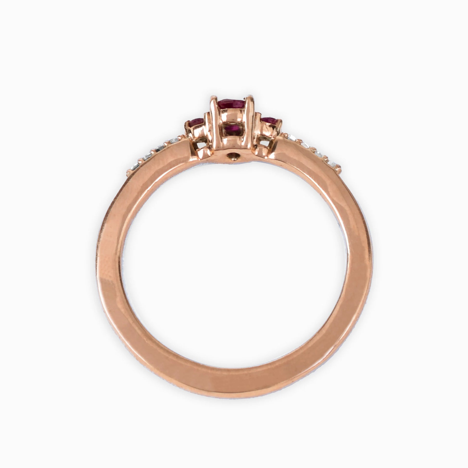 Anillo en oro rosa con rubí central y diamantes laterales.