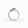 Anillo botánico de Joyería Esterlina en Plata Ley 925 con topacio azul ovalado y esmeraldas laterales.