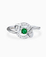 Anillo de Plata Ley 925 talla 5 con un cirón redondo verde en el centro rodeado de ondas caladas con circones blancos.
