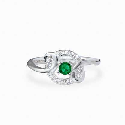 Anillo de Plata Ley 925 talla 5 con un cirón redondo verde en el centro rodeado de ondas caladas con circones blancos.