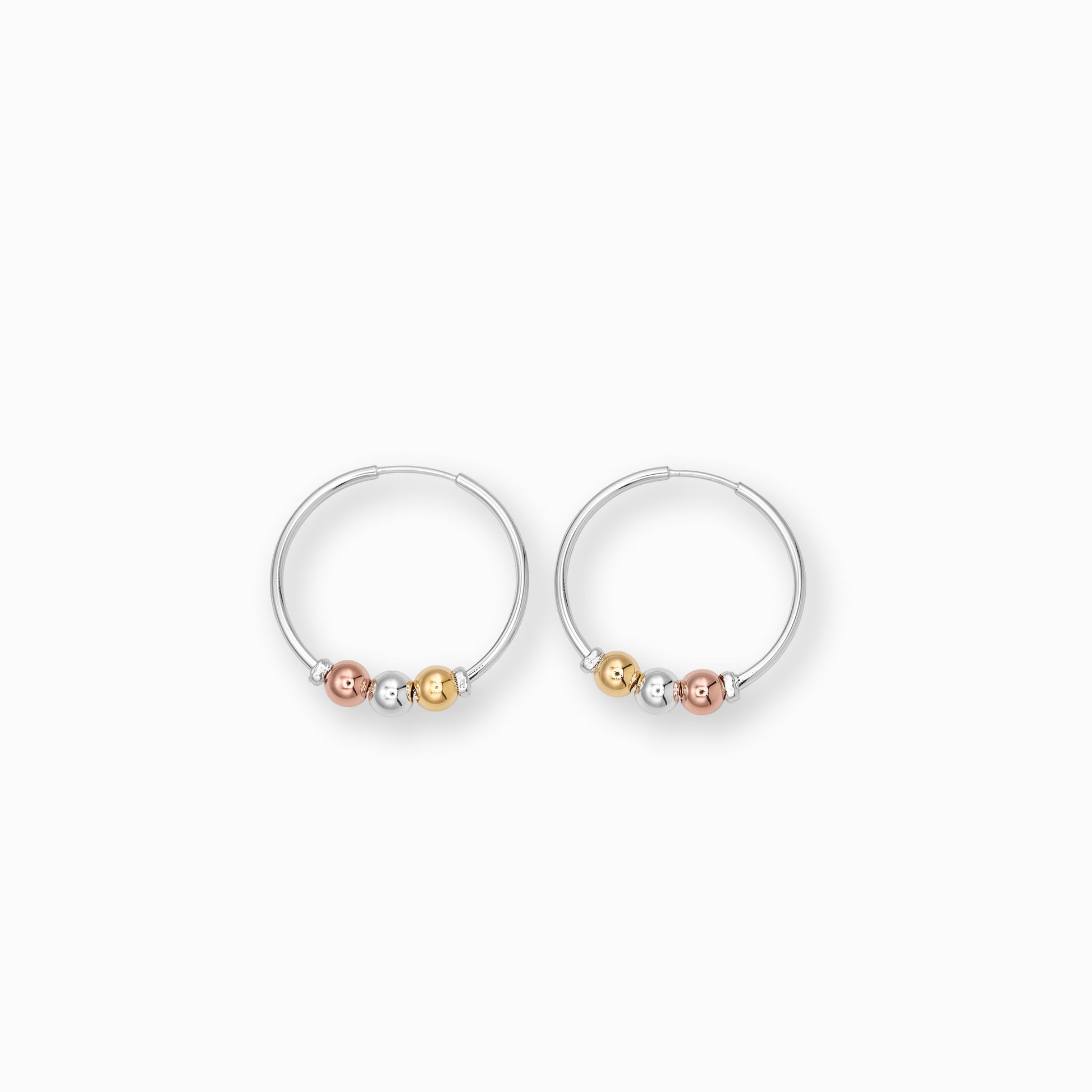 Par de aretes tipo candonga grande en plata ley 925 con tres balines decorativos en tonos plata, oro rosa y oro amarillo de 27 mm sobre fondo blanco.
