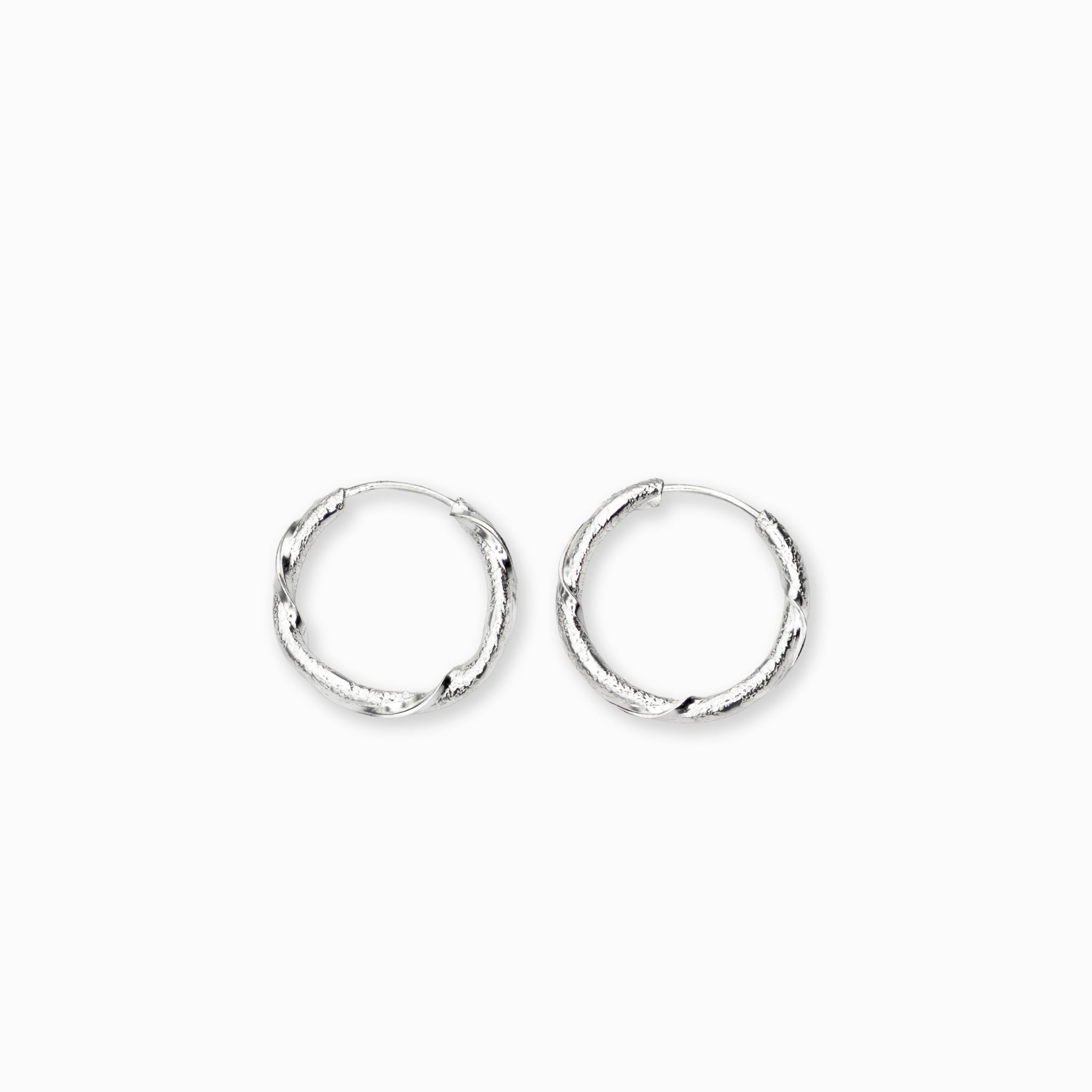 Par de aretes tipo candonga redonda con textura entorchada y acabado martillado elaborados en plata ley 925 de 17 mm de diámetro sobre fondo blanco
