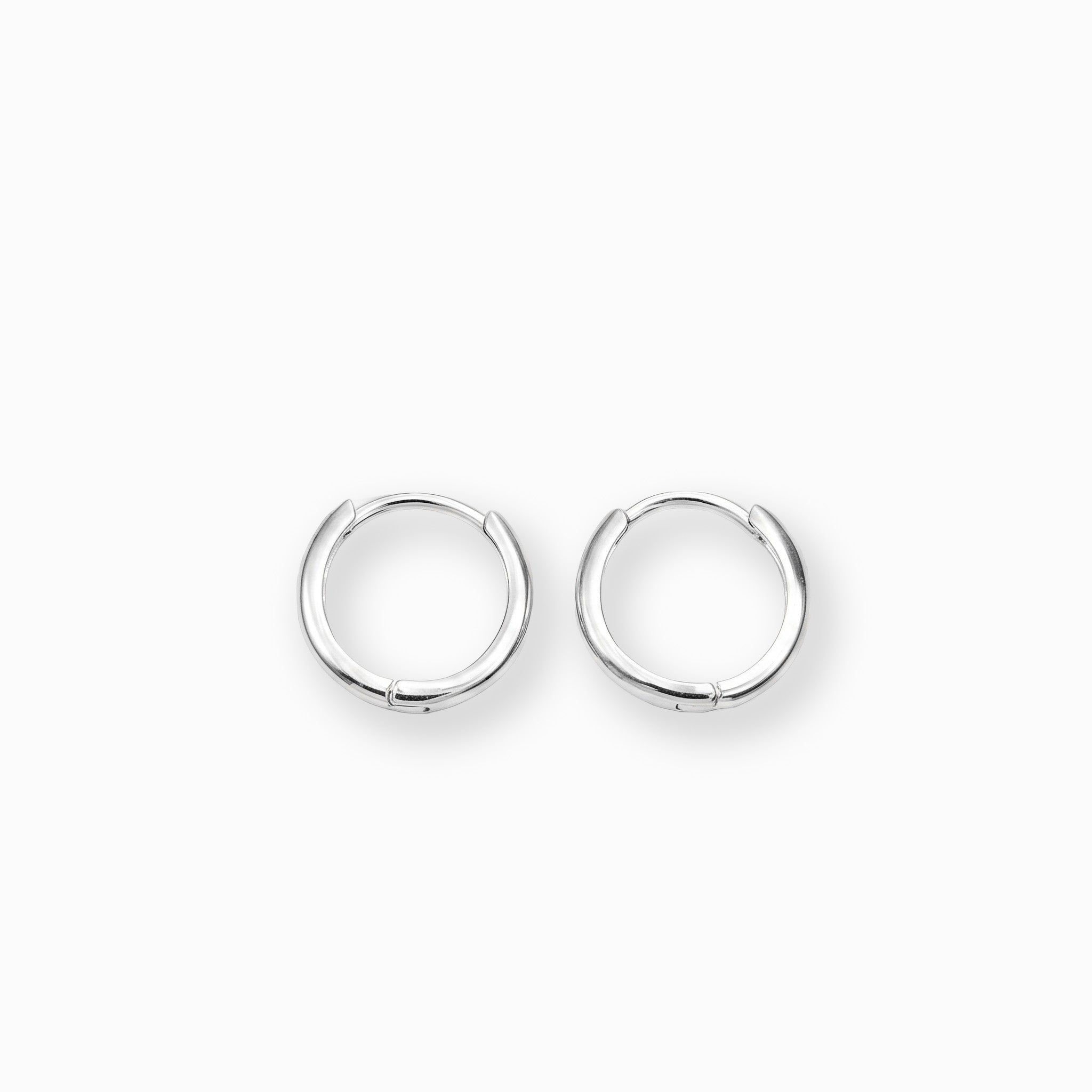 Par de aretes tipo candonga redonda lisa elaborados en plata ley 925 de 14 mm de diámetro sobre fondo blanco
