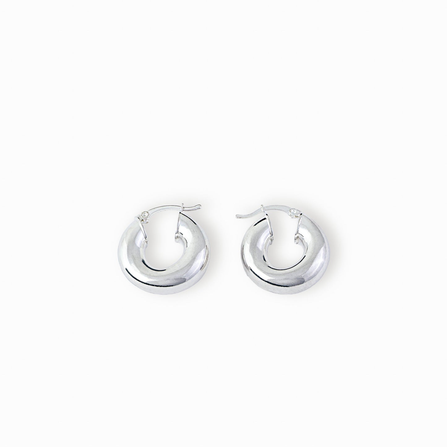 Par de aretes tipo candonga redonda lisa y gruesa elaborados en plata ley 925 de 25 mm de diámetro sobre fondo blanco