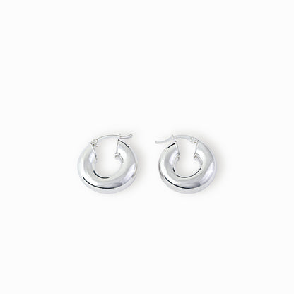 Par de aretes tipo candonga redonda lisa y gruesa elaborados en plata ley 925 de 25 mm de diámetro sobre fondo blanco
