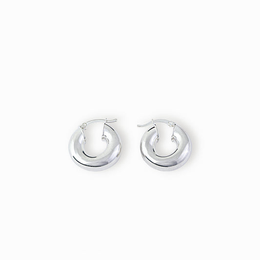 Par de aretes tipo candonga redonda lisa y gruesa elaborados en plata ley 925 de 25 mm de diámetro sobre fondo blanco