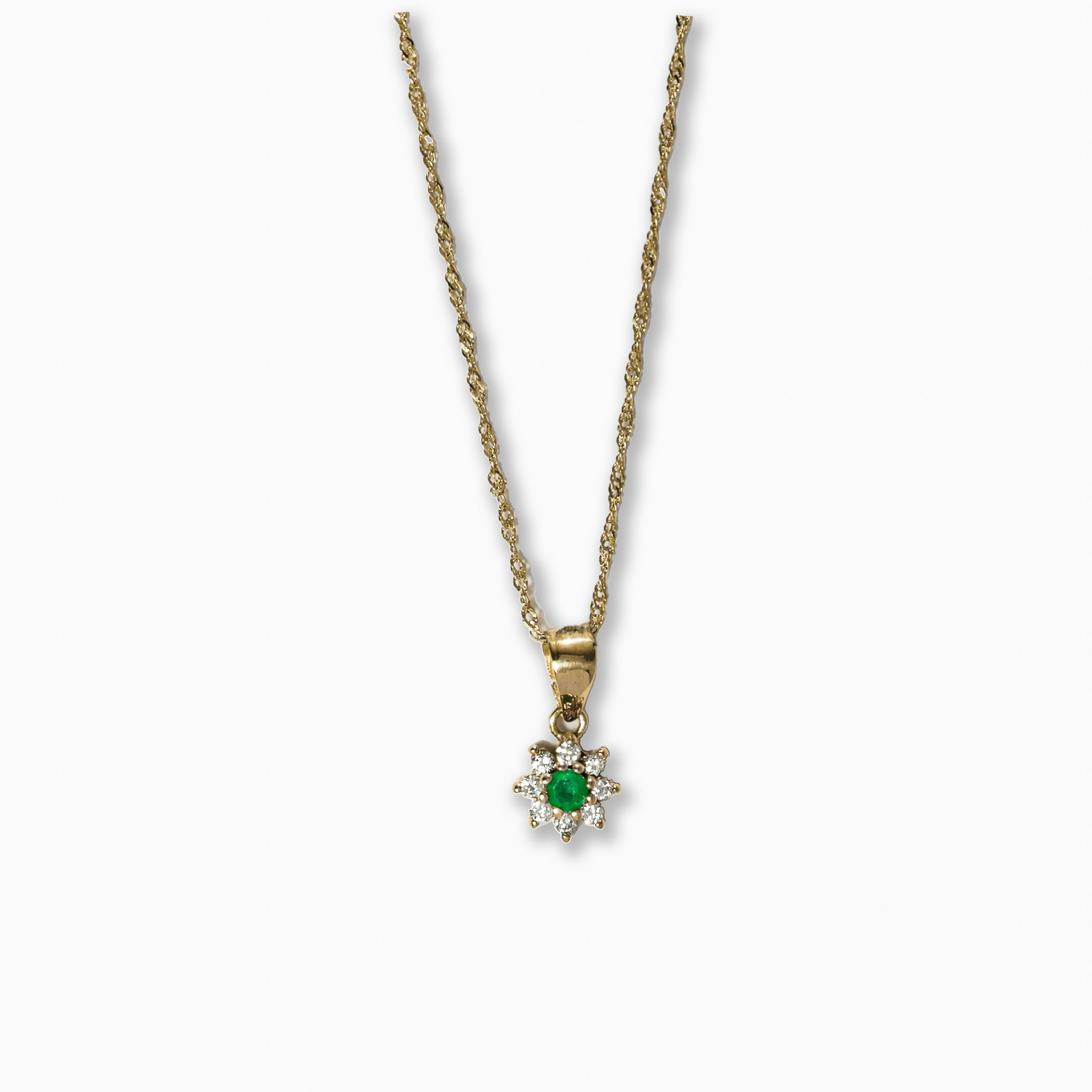 Cadena fina de oro tejido Singapur con un dije de sol en oro de 18k que aloja una esmeralda central rodeada de diamantes.