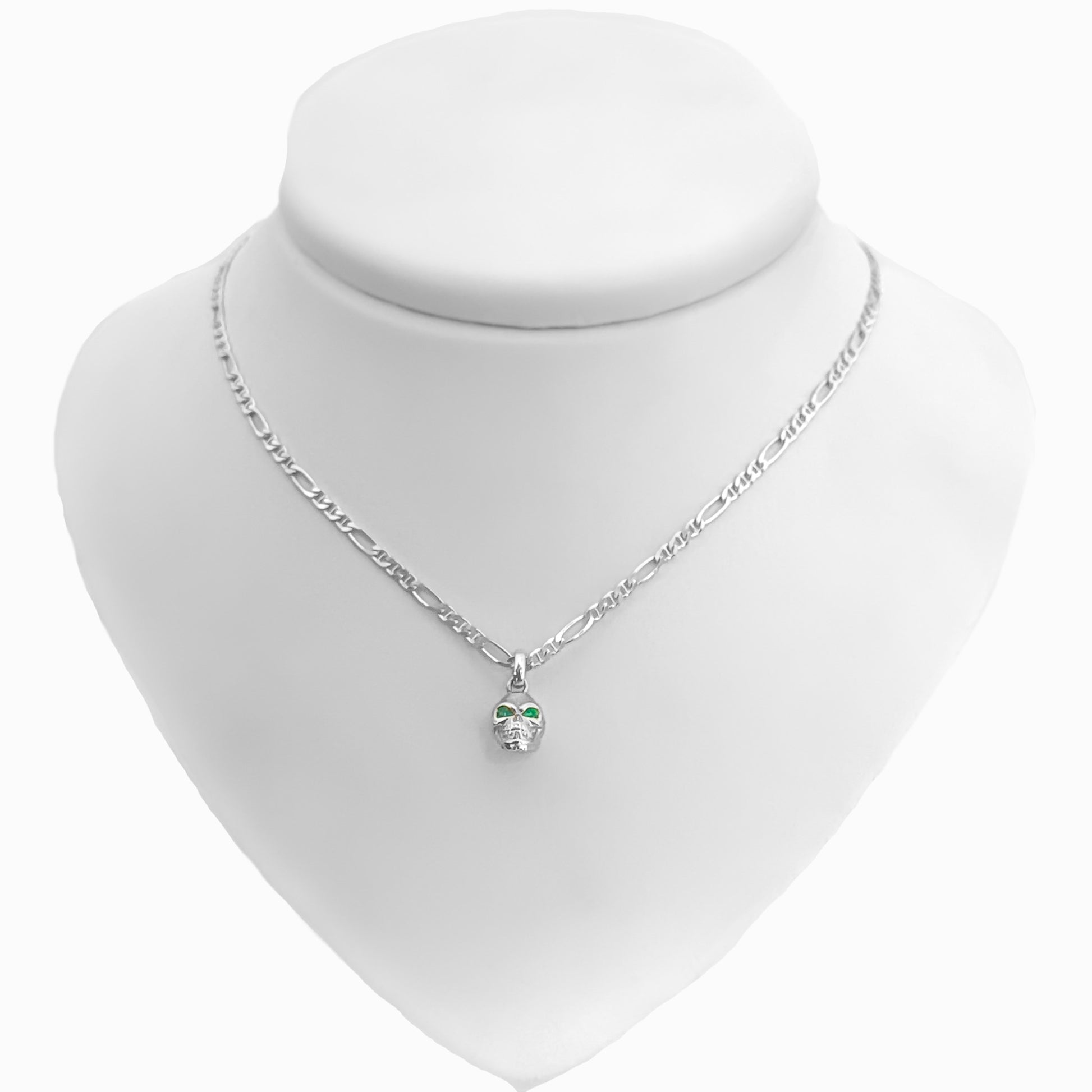 Dije tridimensional de calavera en Plata Ley 925 con dos esmeraldas naturales brillantes engastadas en los ojos.