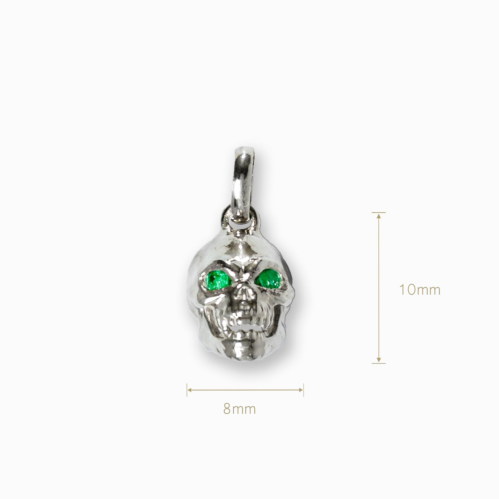 Dije tridimensional de calavera en Plata Ley 925 con dos esmeraldas naturales brillantes engastadas en los ojos.