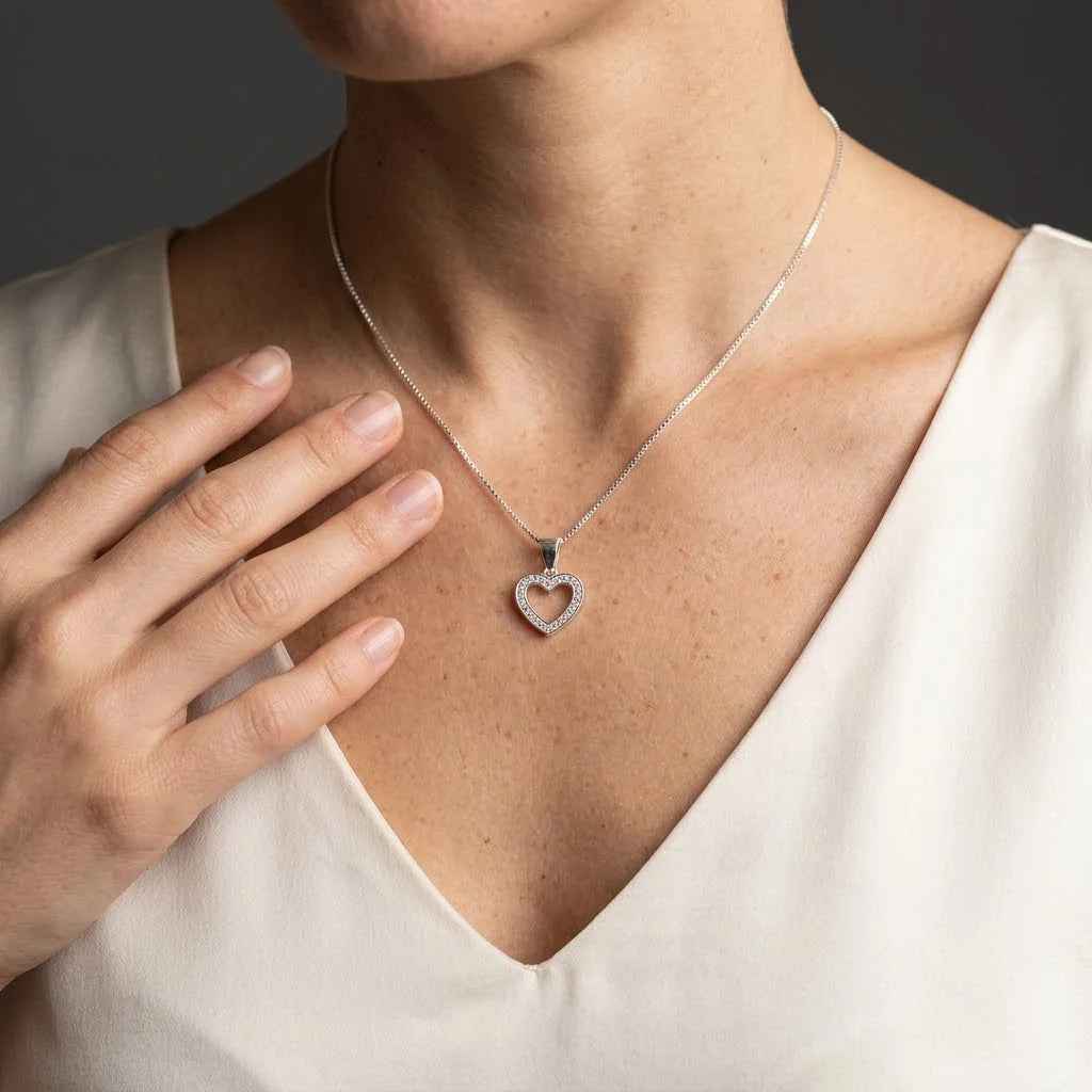 Dije de corazón calado en plata ley 925 con halo de circones blancos brillantes.