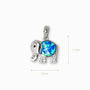 Dije colgante de elefante en Plata Ley 925 de 13x11mm con cuerpo de resina azul estilo ópalo y detalles de circones brillantes.