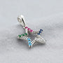 Dije de estrella calada de 15x14 mm en plata ley 925 con circones multicolor