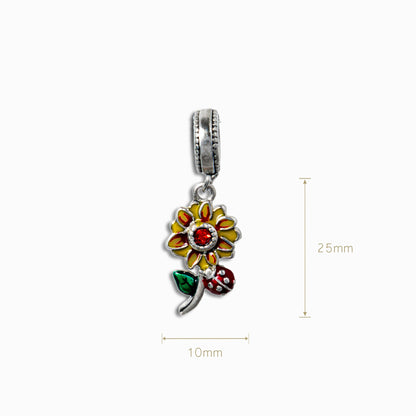 Charm colgante de flor en Plata Ley 925 con esmalte amarillo, centro de cirón rojo y detalle de mariquita sobre fondo blanco.