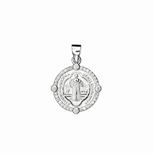 Dije de la medalla de San Benito en plata ley 925 con borde de circones blancos brillantes sobre fondo blanco.