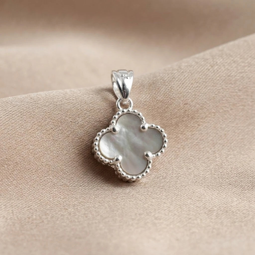 Dije de trébol en plata ley 925 con nácar natural iridiscente de 12 mm.