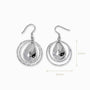 Juego de aretes colgantes en Plata Ley 925 con aros delgados texturizados y una medalla central en forma de gota pulida.