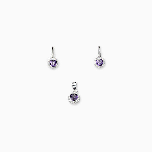 Juego de joyería en plata ley 925 con aretes de cierre bisagra y dije en forma de corazón con circón morado de 7 mm sobre fondo blanco.
