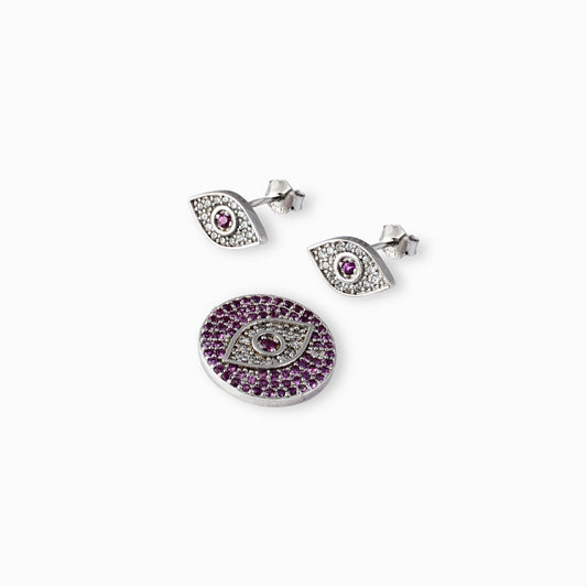 Juego de joyería en plata ley 925 con diseño de ojo místico decorado con circones brillantes, incluye aretes de topo y dije sobre fondo blanco.