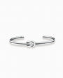 Pulsera rígida tipo aro con detalle de nudo central elaborada en plata ley 925 de 4 mm de grosor sobre fondo blanco.
