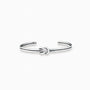 Pulsera rígida tipo aro con detalle de nudo central elaborada en plata ley 925 de 4 mm de grosor sobre fondo blanco.
