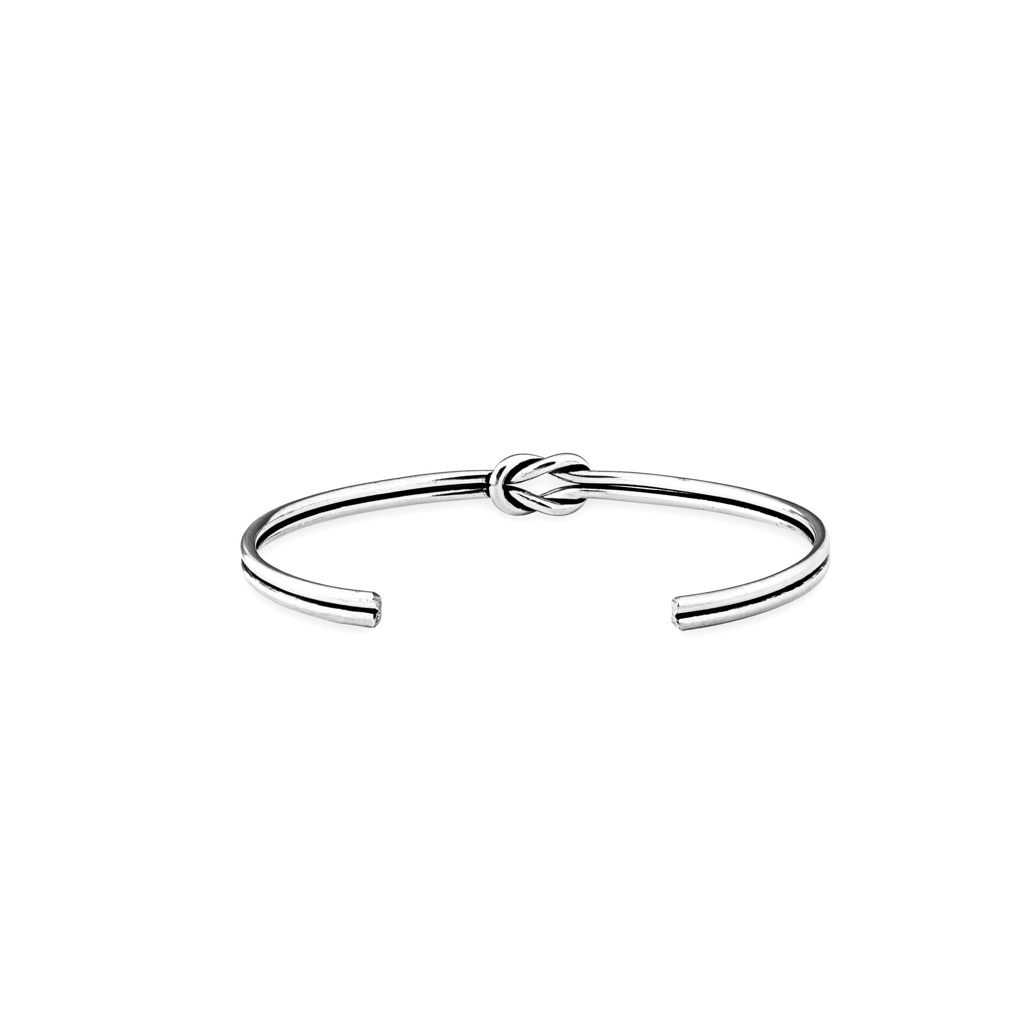 Pulsera rígida tipo aro con detalle de nudo central elaborada en plata ley 925 de 4 mm de grosor sobre fondo blanco.
