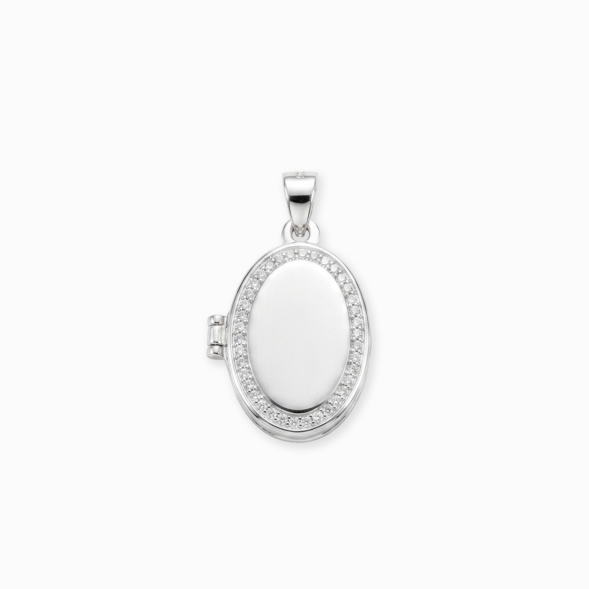  Dije tipo relicario ovalado elaborado en plata ley 925 con borde de circones blancos brillantes sobre fondo blanco.
