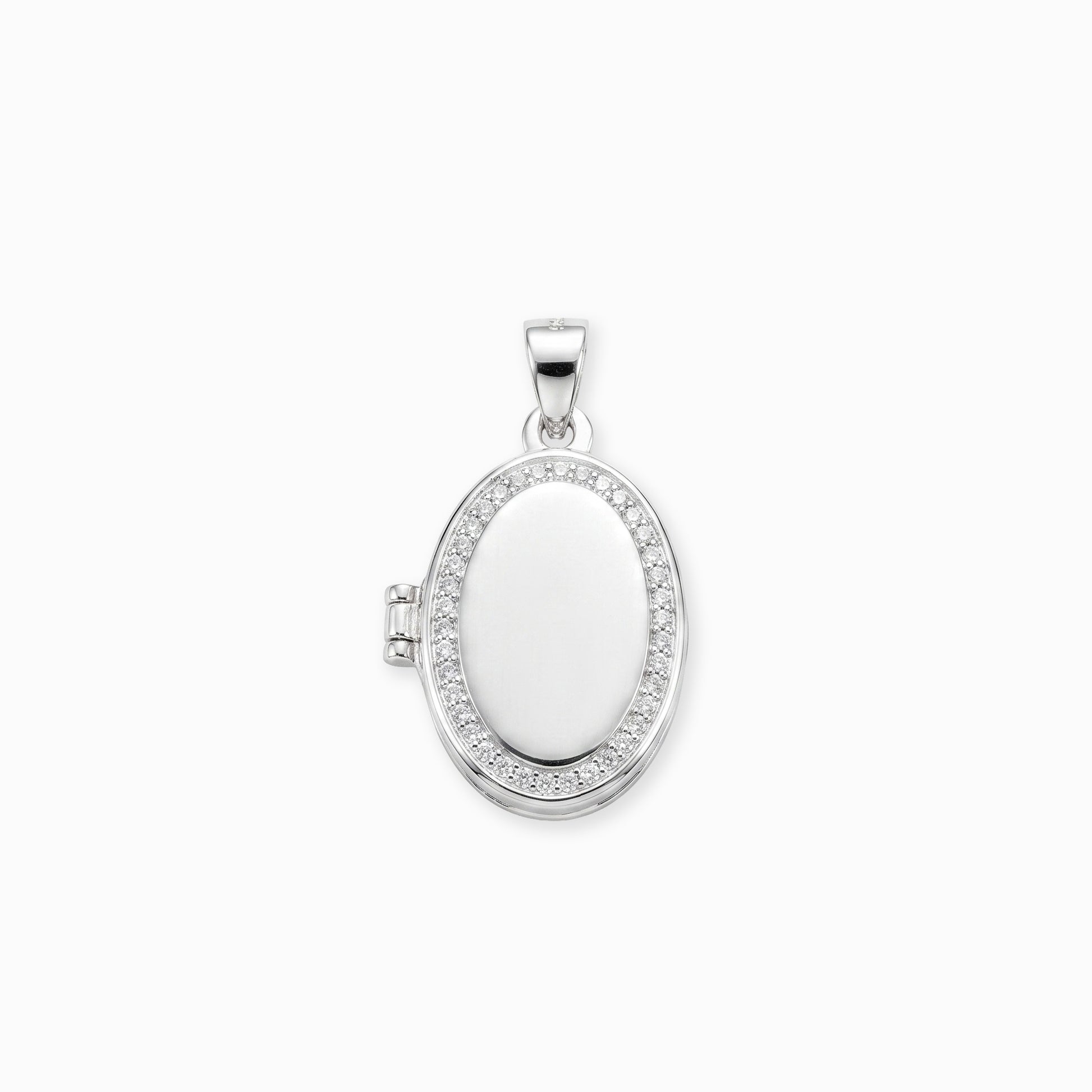 Dije tipo relicario ovalado elaborado en plata ley 925 con borde de circones blancos brillantes sobre fondo blanco.
