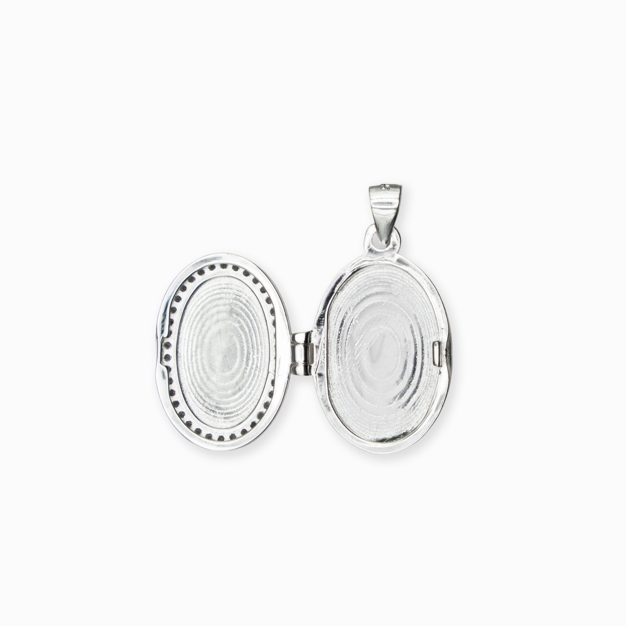  Dije tipo relicario ovalado elaborado en plata ley 925 con borde de circones blancos brillantes sobre fondo blanco.

