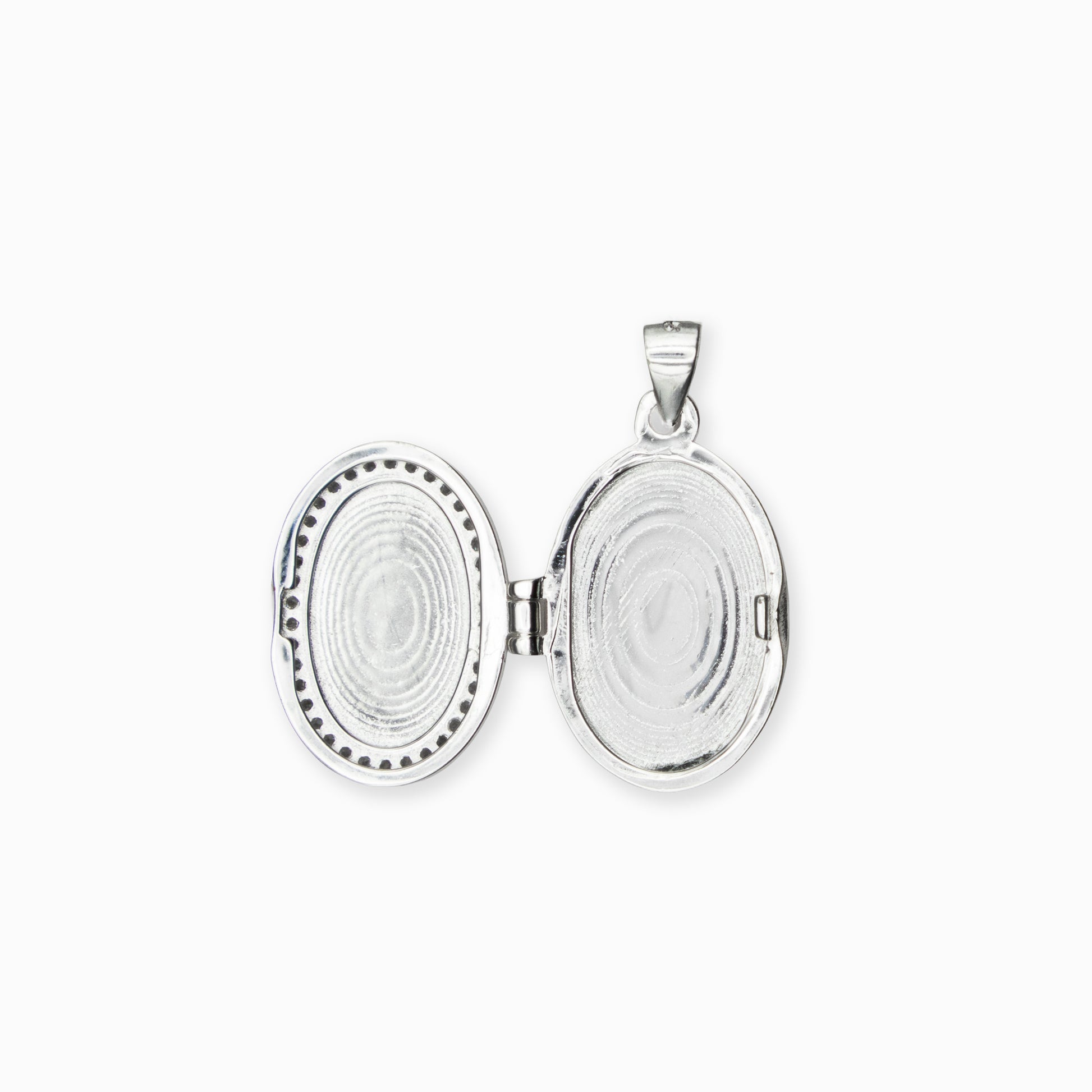  Dije tipo relicario ovalado elaborado en plata ley 925 con borde de circones blancos brillantes sobre fondo blanco.
