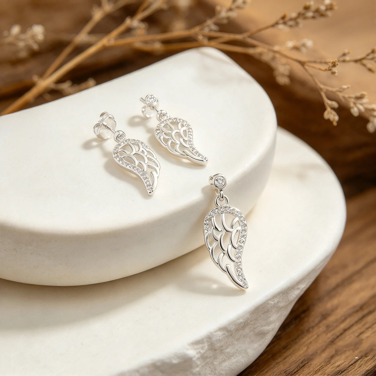 Juego de aretes colgantes y dije en forma de ala celestial calada en plata ley 925 con circones.