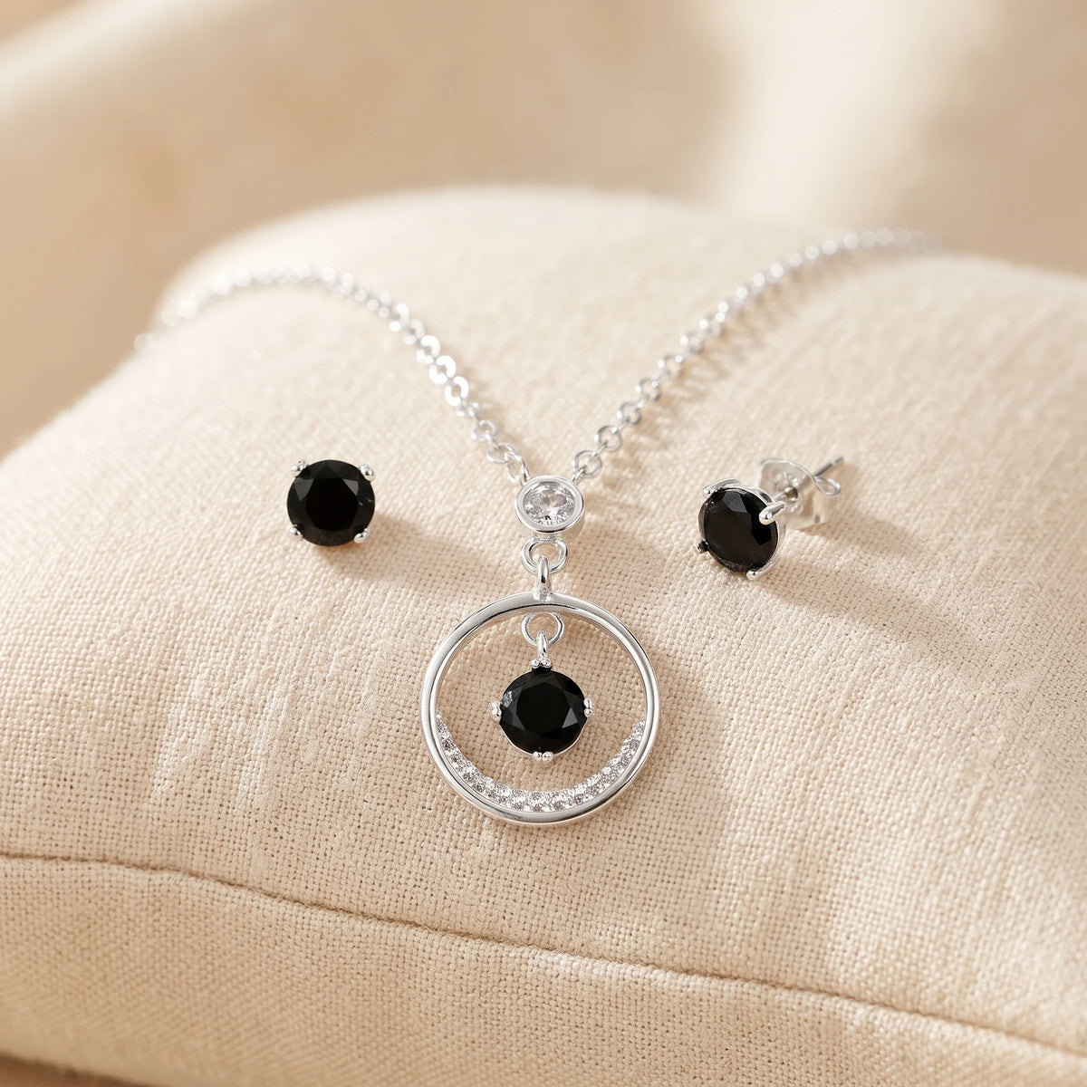 Set de topos y dije circular en plata ley 925 con circon negro central.