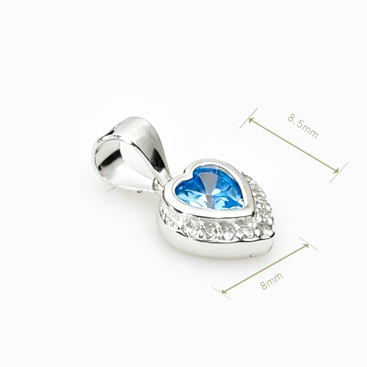 Set de topos y dije con forma de corazón en plata ley 925 con circones azul claro y halo brillante.