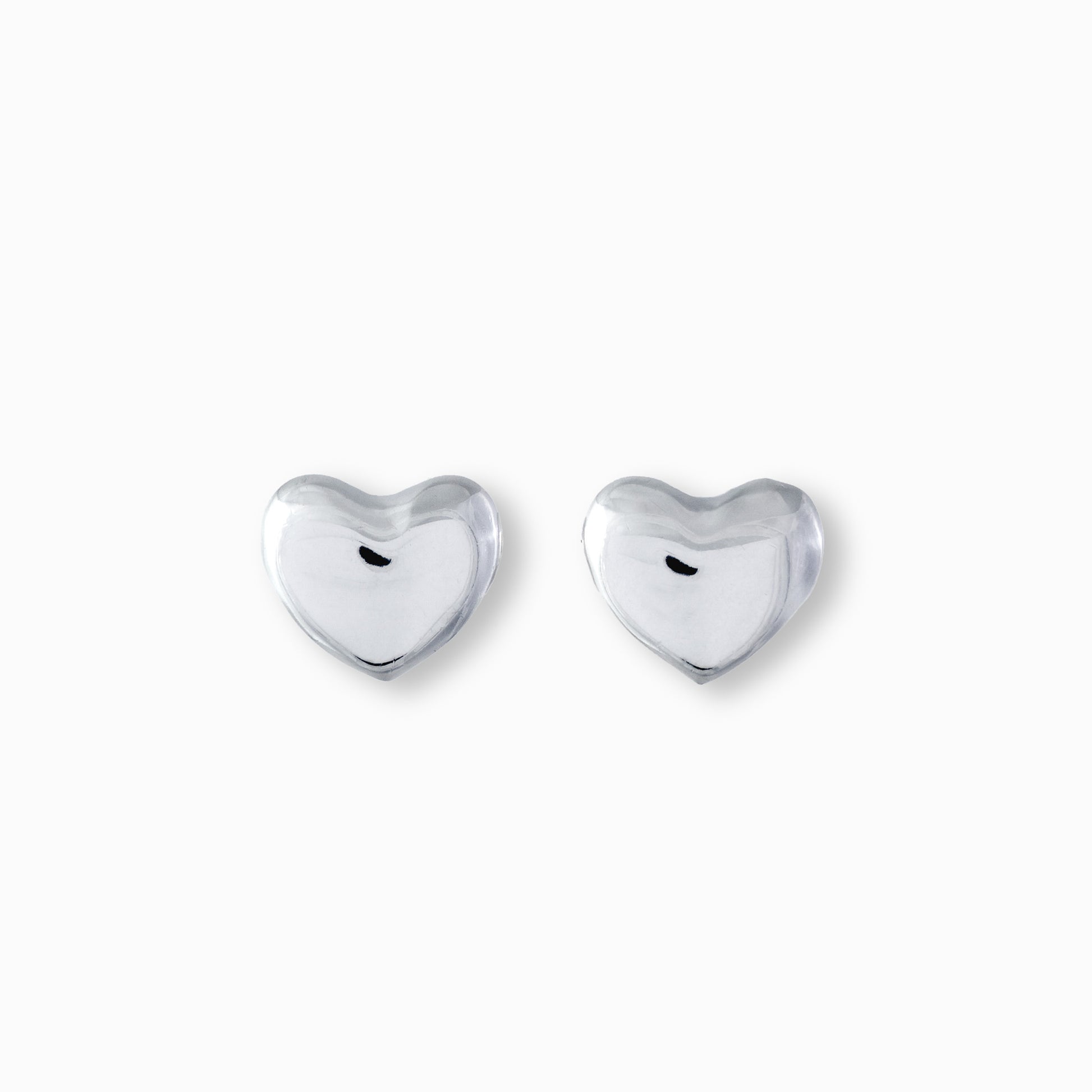 Par de aretes tipo topo con forma de corazón liso y brillante elaborados en plata ley 925 de 12 mm de ancho sobre fondo blanco.
