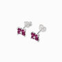 Par de aretes tipo topo con forma de flor de cuatro pétalos elaborados en plata ley 925 con circones rojos brillantes sobre fondo blanco.